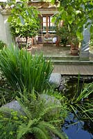 Wooden deck with pond and stone wall. Marina Wust, Germany