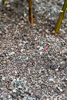 Composted household green waste used as a mulch. Showing small particles of plastic.
