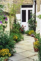 Narrow courtyard garden beside Victorian House. 