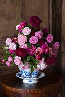 Red and pink roses in a cut flower arrangement on a side table