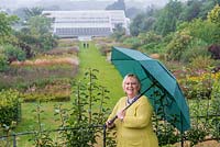 Sue Biggs, director general of the Royal Horticultural Society. Pictured at RHS Wisley in heavy rain, standing on The Mount, looking down the Piet Oudolf borders towards the glasshouse at the bottom of the hill.