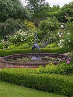 Central brick edged pond with bird sculptures in a rose garden. Box edged beds of roses - 'Comte de Chambord', 'Prosperity', 'Felicia'. 