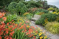 Lanhydrock Garden, otherwise known as the hot garden, full of crocosmias, achilleas, rudbeckias, Salvia confertiflora and bright sedge Carex elata 'Aurea'. Wollerton Old Hall, nr Market Drayton, Shropshire, UK