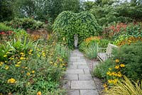 Lanhydrock Garden, otherwise known as the hot garden, full of crocosmias, achilleas, rudbeckias, Salvia confertiflora and bright sedge Carex elata 'Aurea'. Wollerton Old Hall, nr Market Drayton, Shropshire, UK