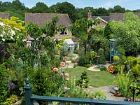 A steeply sloping town garden viewed from a patio terrace. 30 x 13.5m.