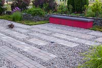 Gravel and brick surface. Dark red bench gives a contrast in general monochromatic set of plant colours
