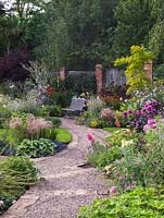 Beds of lychnis, nicotiana, Alstroemeria Spitfire, Verbena bonariensis, bidens, Lavatera Barnsley, allium, onopordum, cercis, robinia, dahlia, sedum, lavender, achillea.