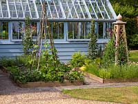 By greenhouse, tiny potager of square raised beds with herbs - oregano, feverfew, chives, parsley, rosemary, sage, thyme, lavender. Sweet peas, beans, fruit trees.