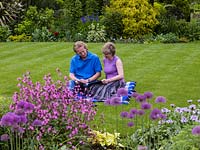 Terry Bartholomew and Margaret Arnott sit on the lawn of their garden