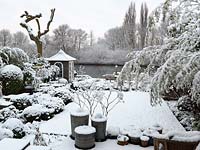 River Thames garden designed by Andy Sturgeon. Box topiary, grasses and architectural plants covered in snow. 

