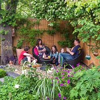 The Monaghan family relax in their town garden, Muswell Hill, London.