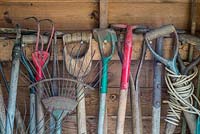 Traditional garden tools stored in potting shed.