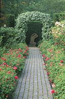 Stable-block path between Rosa officinalis, leading to Sorbus arch and modern sculpture 