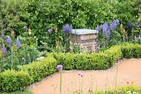 Beehive surrounded by bee friendly planting and Buxus sempervirens hedge, plants include Allium, Camassia, Thalictrum - The Bees Knees in support of The Bumblebee Conservation Trust - RHS Malvern Spring Festival 2015