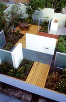 Aerial view of a modern garden with dividing screens, frosted panels, wooden decking and galvansised steel grid surfaces. Designed by Paul Dracott