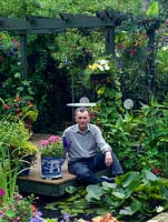 Brian Bowles in his garden Redston Road. On a small sloping plot it is designed on the diagonal to maximise the appearance of width.