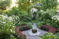 White garden with granite sphere water feature. Berberis thunbergii f. atropurpurea 'Atropurpurea Nana', Paeonia 'Krinkled White', Stachys byzantina 'Big Ears'.