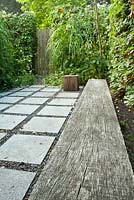 Stone paving in squares patio with bench.