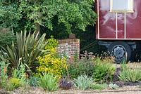 Gravel garden planted with Phormium tenax 'Purpureum', Escallonia leavis 'Gold Ellen', Iris pallida 'Argentea Variegata', Sedum 'Matrona', Sedum 'Red Cauli', Geum 'Totally Tangerine', Knifophia 'Elvira'