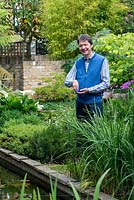 Rupert King who created his water garden on a blank canvas, inspired by Persian Paradise and Japanese gardens. Pictured feeding the fish.