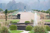 View down the Italian Garden towards the lake. Includes topiary balls, fountain, clipped Portuguese laurels and grasses. Trentham Gardens
 
