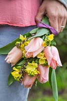 Woman holding Floral bouquet made with Tulipa 'Menton' and Cheiranthus cheiri 'Ivory White'