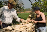 Father and daughter - John and Lou Shone building up a dry stone wall
