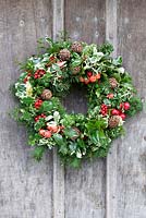 Christmas wreath hanging on rustic door.