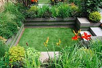 Sunken garden with artificial lawn, surrounded by flower borders - Foundation For Growth garden, RHS Hampton Court Palace Flower Show 2015