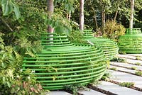 Three green tubular metal seat around Birch trees. Designer Ann-Marie Powell Gardens. Sponsor: Macmillan Cancer Support