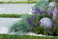 View of stone globe and grey stone slabs surrounded by Festuca glauca - blue fescue grass, Lavandula, Thymes.  Healing Urban Garden   -   RHS Hampton Court Palace Flower Show 2015