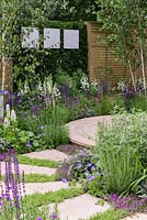 The Wellbeing of Women Garden. a circular patio is edged in medicinal and sensory plants, in purples, blues and whites. Designers: Claire Moreno, Wendy von Buren and Amy Robertson.