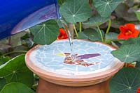 Filling the mosaic bird bath with water