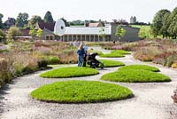 Visitors to garden. View to the Gallery from the Oudolf FieldHauser and Wirth, Bruton, Somerset. Planting design by Piet Oudolf.