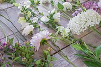 Ingredients required for constructing a White and Purple Bouquet. Plants include Scabiosa caucasica 'Fama White', Chamerion angustifolium, Lupinus polyphyllus 'Gallery White', Abelia x grandiflora, Foeniculum vulgaris, Rosa 'Tranquility', Dahlia 'Eveline', Digitalis purpurea 'Camelot White', Nicotiana affinis, Clematis viticella 'Polish Spirit', Hydrangea arborescens 'Annabelle', Dahlia 'White Aster', Jasminum officinale, Artemisia 'Powis Castle' and Cosmos bipinnatus 'Purity'