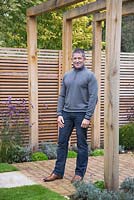 Garden designer Sean Butler of Cube 1994, standing beneath the pergola