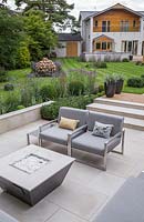 Wide garden overview featuring the sunken seating area and unique gabion sculpture shaped like a bulb