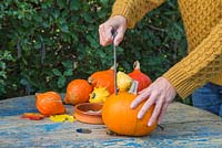 Pierce three holes which penetrate both ends of the Pumpkin, creating the holes in a triangular formation