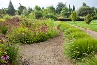 Summer borders. Gaillardia grandiflora 'Burgundy', Echinacea purpurea, Echinacea purpurea Alba, Pennisetum alopecuroides 'Hameln'. Shell path.