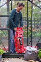 Vigorously shake the Tomato grow bag to loosen the soil