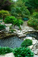 View from above to water garden with interconnecting pools with planting for an exotic foliage feel.  Hosta, Trachycarpus fortune - Chusan palm. 