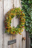 An autumnal wreath featuring pyracantha, ivy seed heads and hawthorn