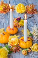 Small gourds used as candle holders accompanied with nasturtium flowers
