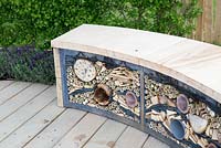 Wildlife friendly garden, reclaimed wooden garden bench with insect shelter, drilled logs, bamboo and old carpet, reclaimed timber decking - The Sanctuary Garden for St Michael's Hospice, designed by Hannah Genders, RHS Malvern Spring Festival 2015