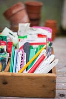 Partitioned wooden box with seed packets, various labels and pencils.