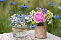 Summer cut flowers in glass jars decorated with twine.