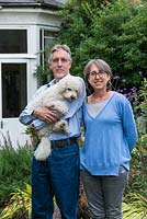 Laura Wahburn Hutton, cookery writer and Ian Pollock in their London garden with Ted, a bichon frise dog.
