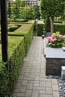 Paved path in small garden with parterre and raised bed. Family Fabry - Mathijs. Belgium