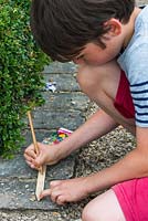 Oscar Isaac, 9, writes plant label for his vegetable patch.