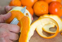 Rest the orange in your spare hand and gently peel with a downwards spiral